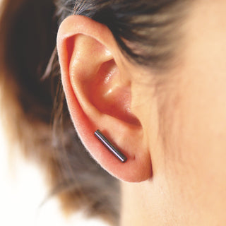 Black bar earrings on ear